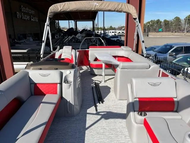 Slide: The Image of 2025 Bennington 21L Cruise pontoon boat with red and gray seating, displayed at dealership. - 12