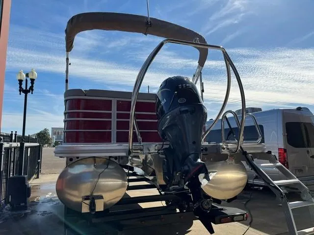 Slide: The Image of 2025 Bennington 21L Cruise pontoon boat with outboard motor, docked under clear sky. - 6