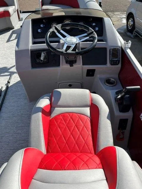 Slide: The Image of 2025 Bennington 21L Cruise boat interior with red and gray seating and steering console. - 9
