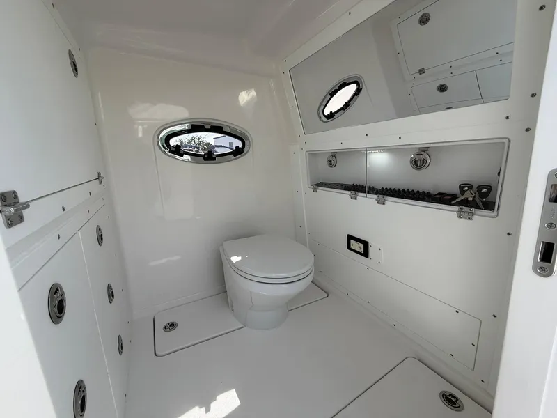 Slide: The Image of 2025 Caymas 34 CT boat interior bathroom with modern white design and porthole window. - 19