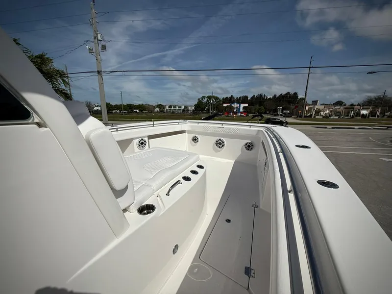 Slide: The Image of 2025 Caymas 34 CT boat interior with seating and cup holders, under a clear blue sky. - 23