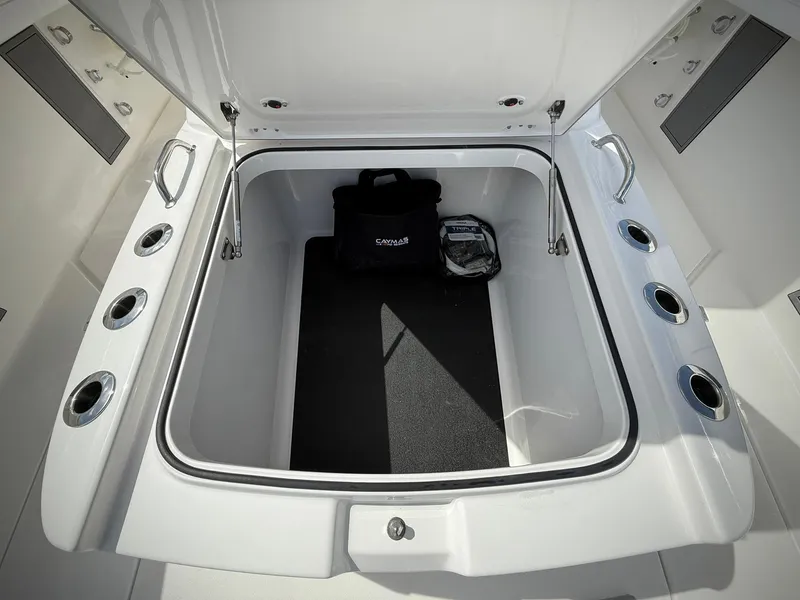 Slide: The Image of 2025 Caymas 34 CT boat storage compartment with open lid and accessories inside. - 32