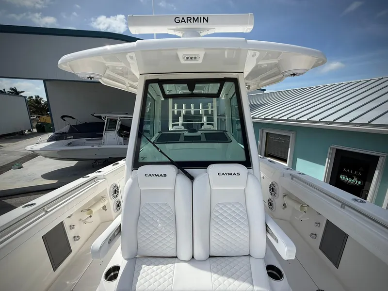 Slide: The Image of 2025 Caymas 34 CT boat interior with Garmin equipment, featuring white cushioned seating. - 33