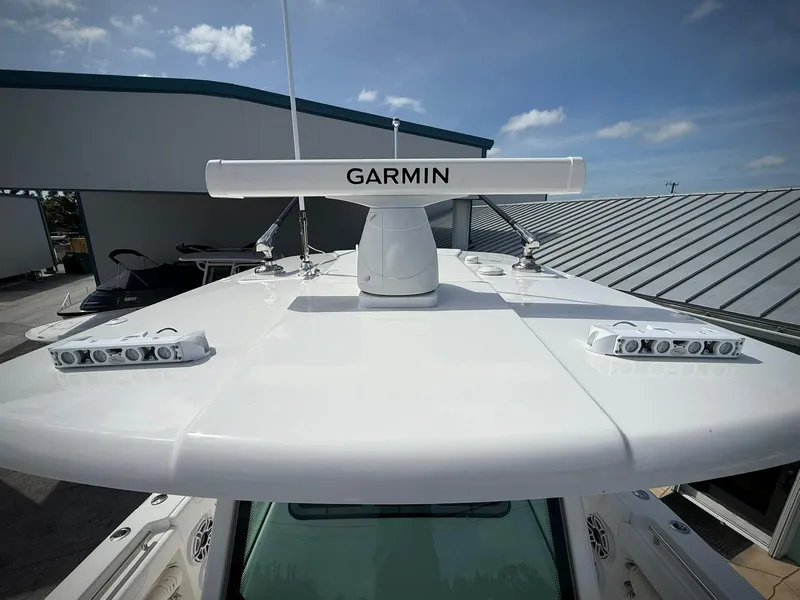 Slide: The Image of 2025 Caymas 34 CT boat with Garmin radar on the roof, under a clear sky. - 34