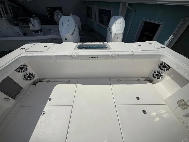 Slide: The Image of 2025 Caymas 34 CT boat deck with storage compartments and twin outboard engines. - 8