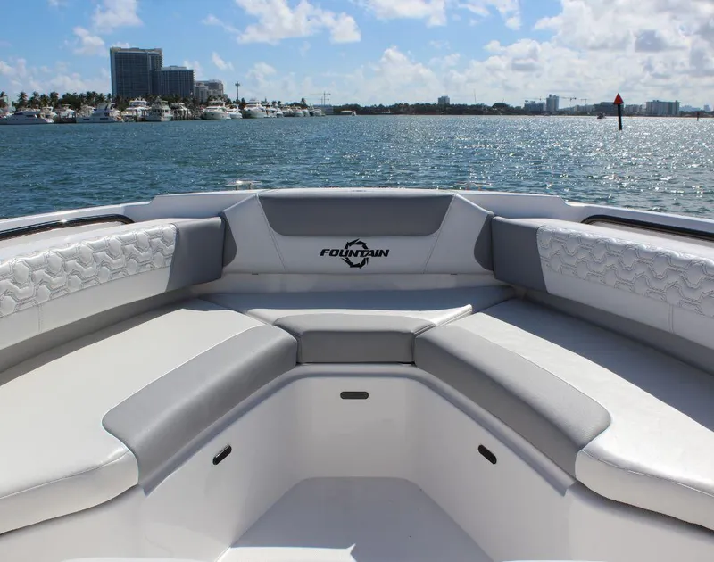 Slide: The Image of 2025 Fountain 32 NX boat interior with luxurious seating, overlooking a scenic waterfront. - 11