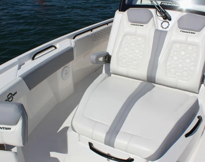 Slide: The Image of 2025 Fountain 32 NX boat interior with white cushioned seating and sleek design. - 16