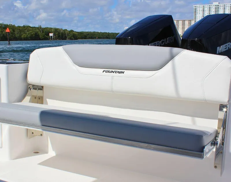 Slide: The Image of 2025 Fountain 32 NX boat seat with dual Mercury engines in scenic waterway. - 19