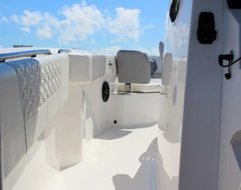 Slide: The Image of 2025 Fountain 32 NX boat interior with cushioned seating and clear blue sky. - 29