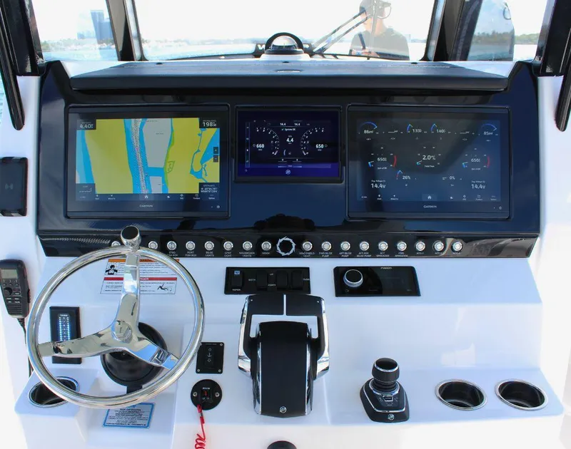 Slide: The Image of 2025 Fountain 32 NX boat dashboard with navigation screens and steering wheel. - 30