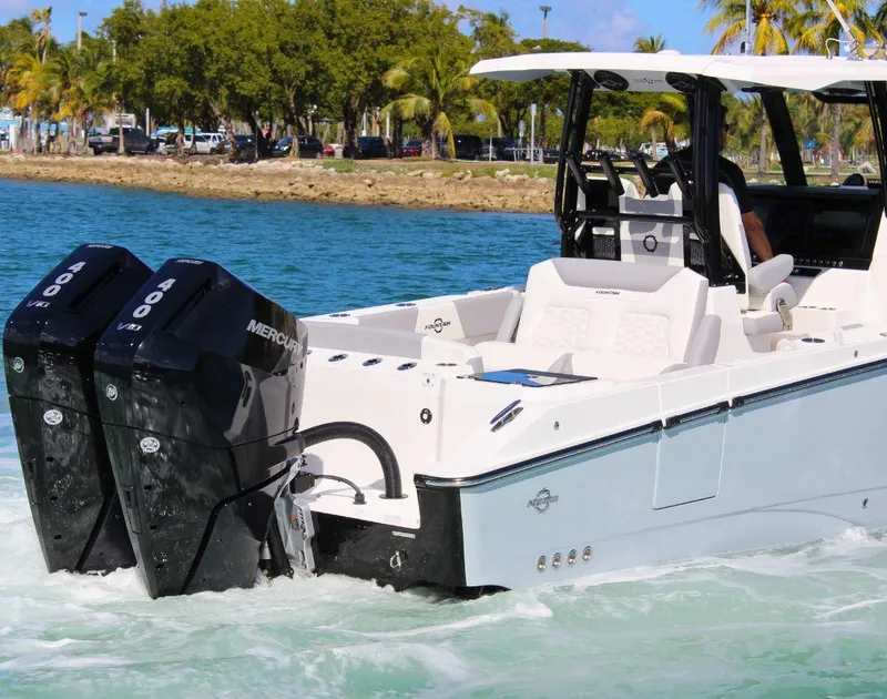 Slide: The Image of 2025 Fountain 32 NX boat with dual Mercury engines cruising on clear water. - 8