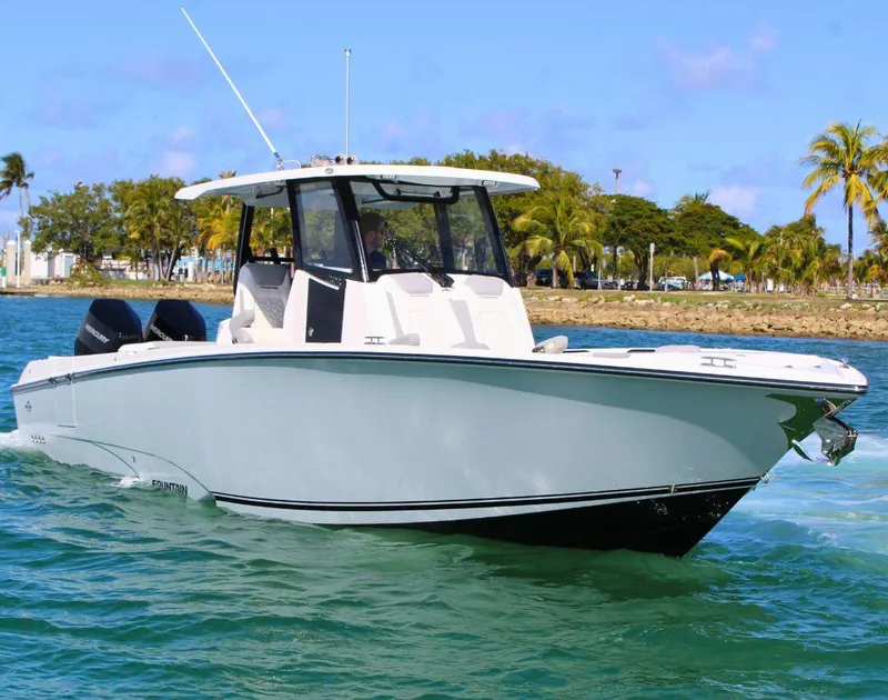 Slide: The Image of 2025 Fountain 32 NX boat cruising on tropical waters with palm trees in the background. - 9