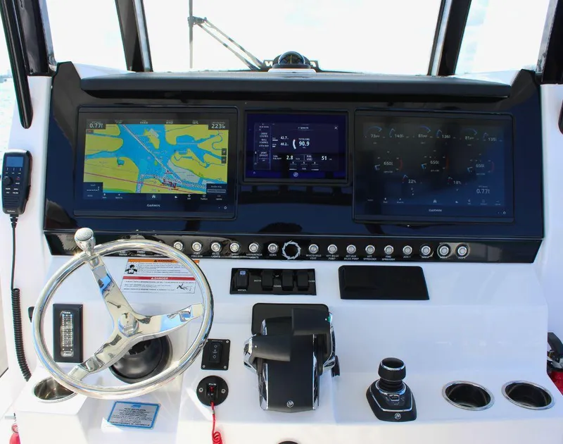Slide: The Image of Control panel of 2025 Fountain 38 CC boat with navigation screens and steering wheel. - 11