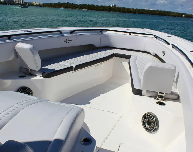 Slide: The Image of 2025 Fountain 38 CC boat interior with white seating and ocean backdrop. - 19