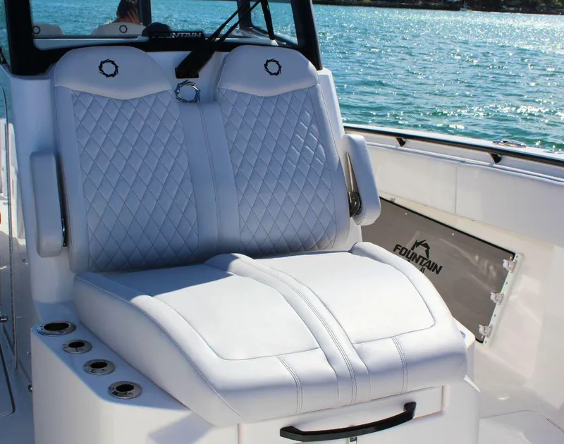 Slide: The Image of Luxury seating on 2025 Fountain 38 CC boat, featuring diamond-stitched upholstery by the water. - 22
