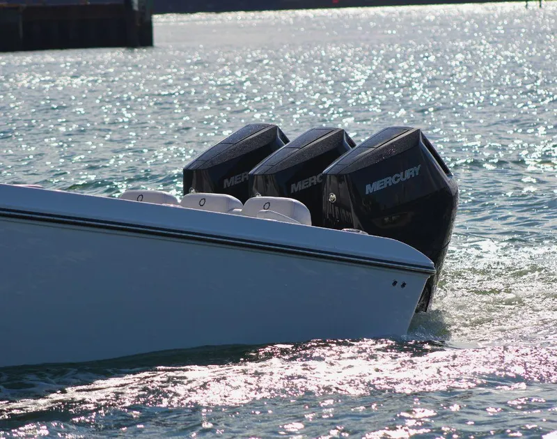 Slide: The Image of 2025 Fountain 38 CC boat with triple Mercury engines on shimmering water. - 3