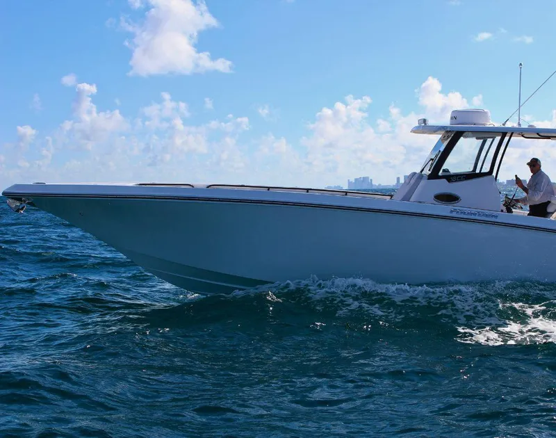 Slide: The Image of 2025 Fountain 38 CC boat cruising on open water under a clear blue sky. - 4