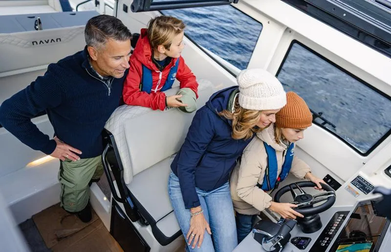 Slide: The Image of Family enjoying a ride on a 2025 Navan C30 boat, navigating through water. - 7