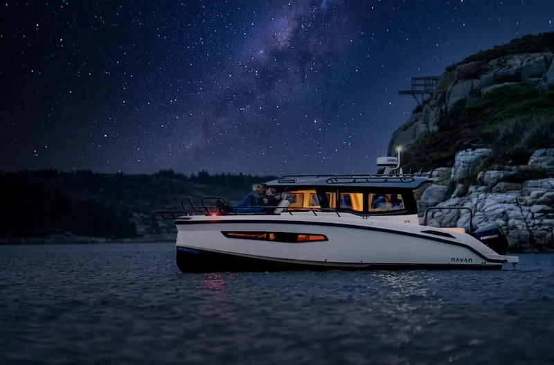 Slide: The Image of Navan C30 boat under starry night sky near rocky shoreline, 2025 model. - 9