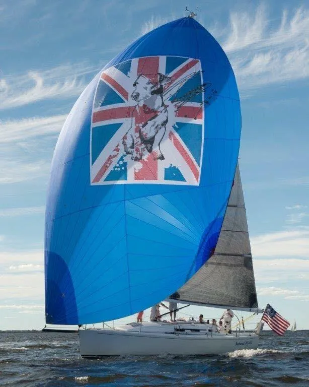 Slide: The Image of 2003 J Boats J/109 sailing with a vibrant blue spinnaker featuring a Union Jack design. - 1