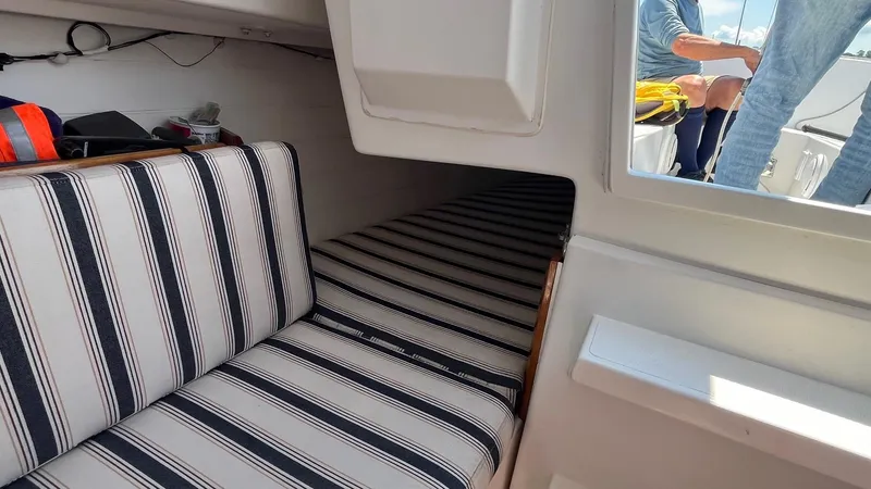 Slide: The Image of Interior of a 2012 Schock Harbor 25 sailboat with striped seating and cabin view. - 15