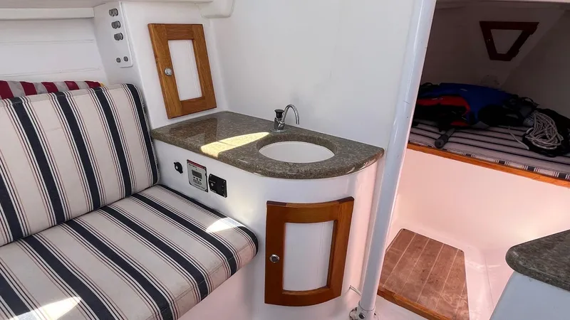Slide: The Image of Interior of 2012 Schock Harbor 25 sailboat with striped seating and compact sink area. - 17
