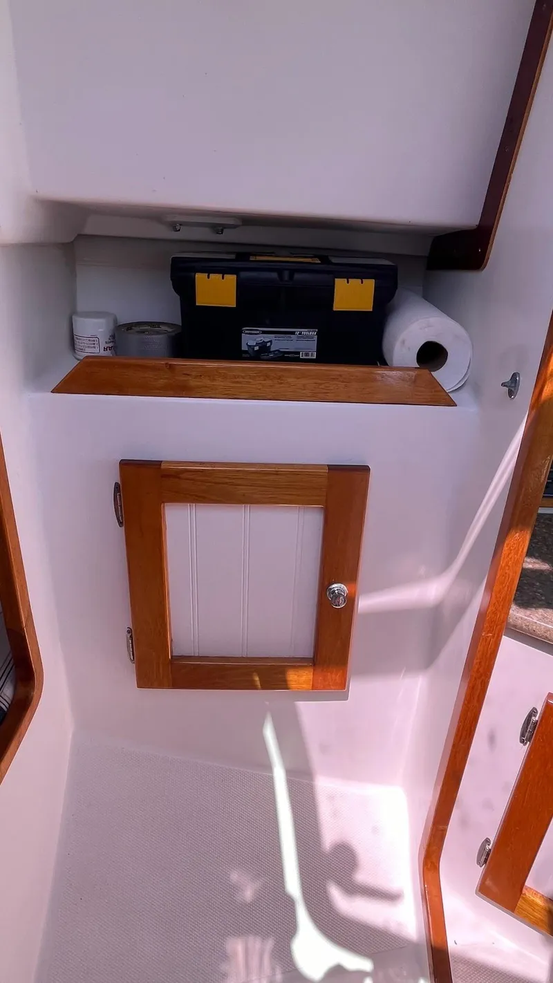 Slide: The Image of Interior storage area of a 2012 Schock Harbor 25 sailboat with wooden trim. - 19