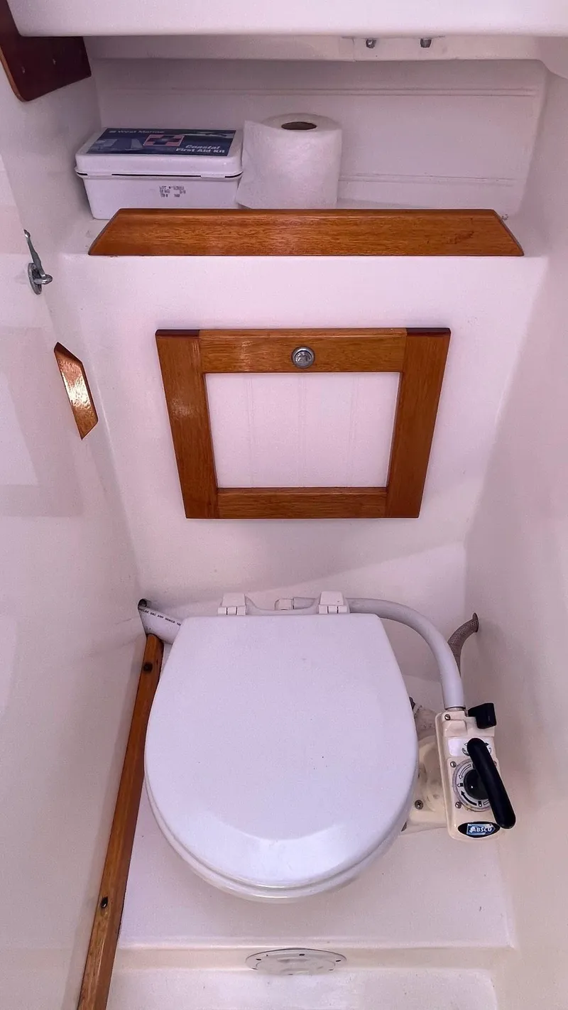 Slide: The Image of 2012 Schock Harbor 25 boat bathroom with toilet and wooden accents. - 24