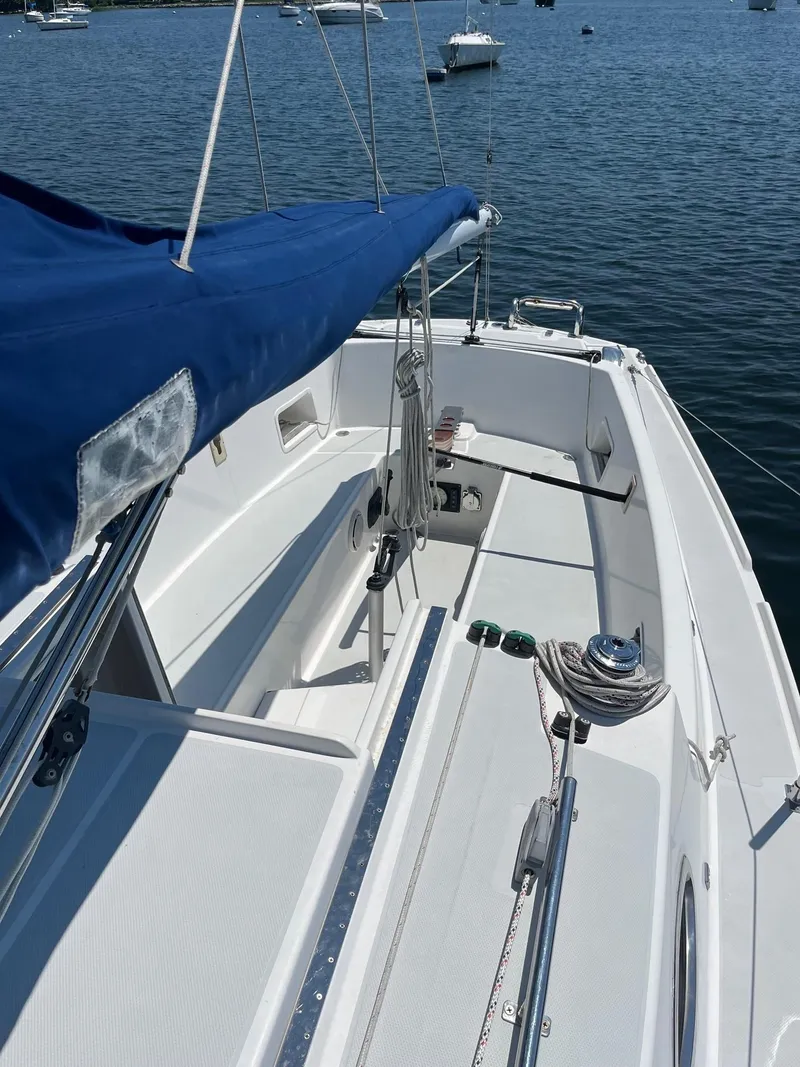 Slide: The Image of 2012 Schock Harbor 25 sailboat with blue sail cover on calm water. - 5