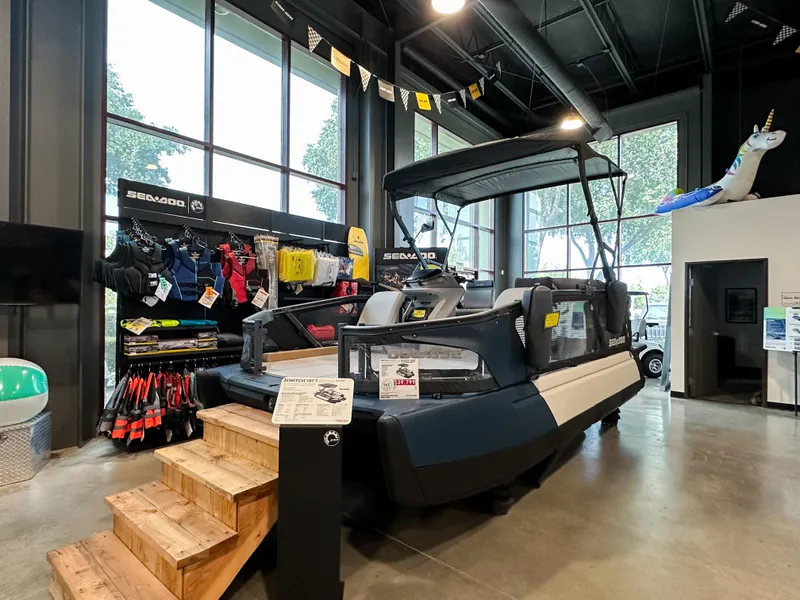 Slide: The Image of 2025 Sea-Doo Switch Sport 18 displayed in showroom with accessories. - 2