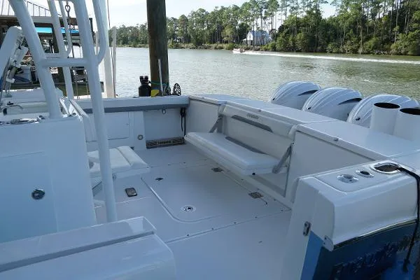 Slide: The Image of 2016 Everglades 435CC boat interior with seating, docked by a scenic river. - 17