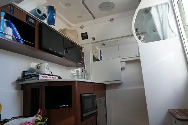 Slide: The Image of Interior of 2016 Everglades 435CC boat with kitchenette and storage cabinets. - 19
