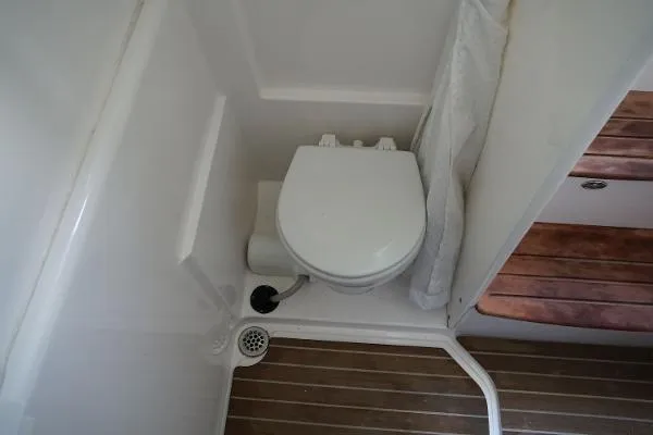 Slide: The Image of 2016 Everglades 435CC boat bathroom with compact toilet and wooden flooring. - 21