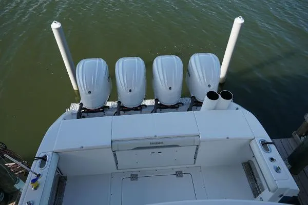 Slide: The Image of 2016 Everglades 435CC boat with four outboard engines, docked on calm water. - 22