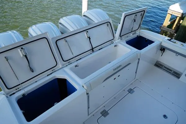 Slide: The Image of 2016 Everglades 435CC boat with open storage compartments, docked by the water. - 23