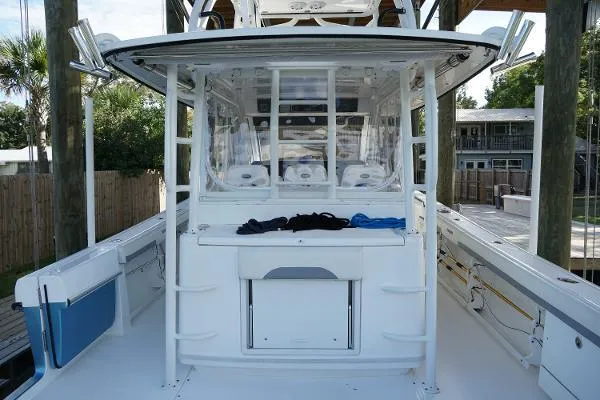 Slide: The Image of 2016 Everglades 435CC boat interior with seating and storage, docked outdoors. - 25
