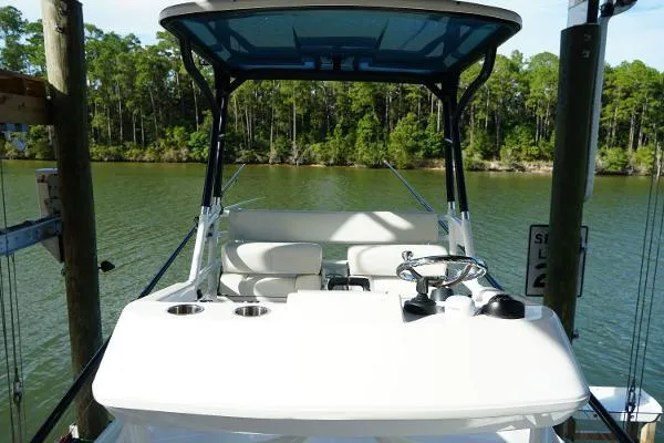 Slide: The Image of 2016 Everglades 435CC boat docked on a serene lake with lush forest backdrop. - 26