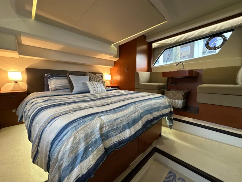 Slide: The Image of Luxurious bedroom interior of a 2015 Prestige 500 S yacht with striped bedding. - 1