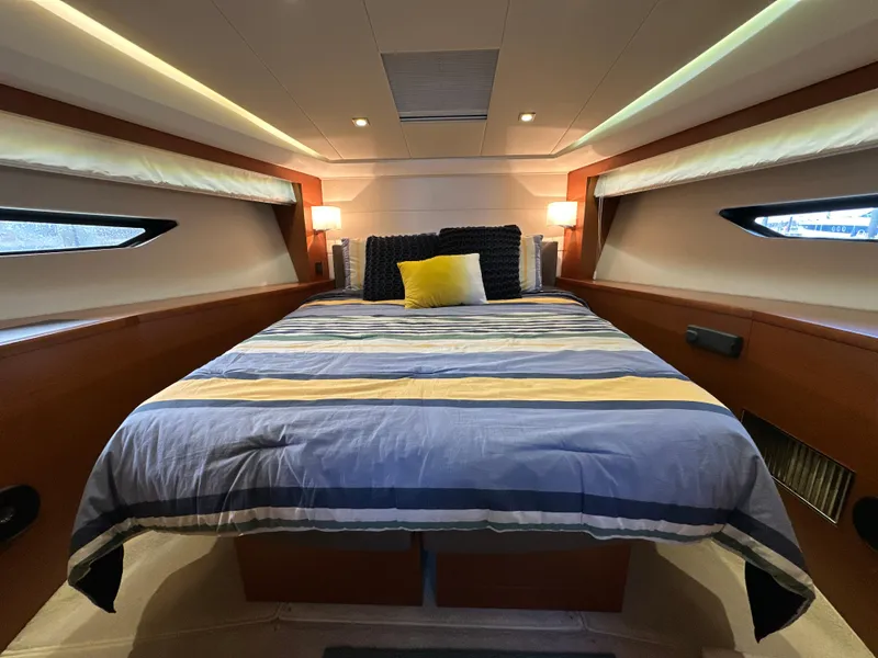 Slide: The Image of Luxurious bedroom interior of 2015 Prestige 500 S yacht with striped bedding and ambient lighting. - 26