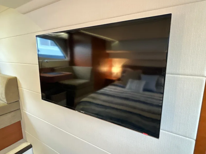 Slide: The Image of Flat-screen TV in 2015 Prestige 500 S yacht interior, with cozy bedroom and seating area. - 41