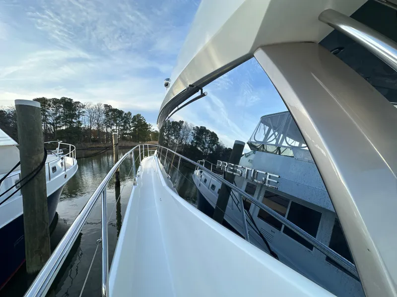 Slide: The Image of 2015 Prestige 500 S yacht docked, reflecting water and trees. - 7