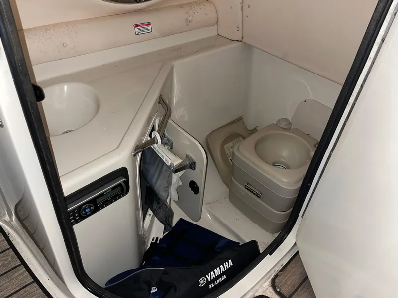 Slide: The Image of 2002 Sea Ray 270 Sundeck interior with compact marine toilet and sink. - 12