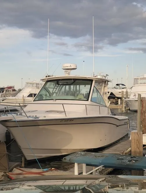 The Image of 2015 Grady-White 330 Express boat docked at marina under cloudy sky. - 1
