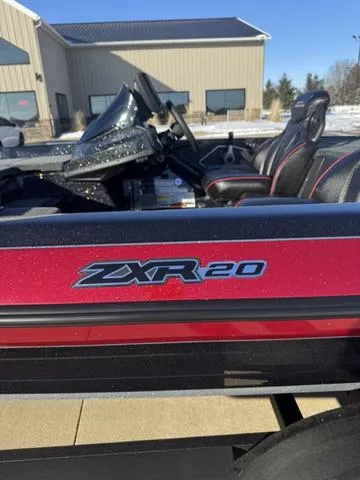 Slide: The Image of 2025 Skeeter ZXR20 boat with red detailing, parked outdoors near a building. - 2