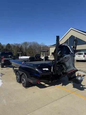 Slide: The Image of 2025 Skeeter ZXR21 boat on trailer, parked outdoors under clear blue sky. - 4