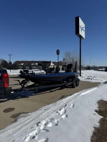 Slide: The Image of 2025 Skeeter ZXR21 boat on trailer in snowy parking lot under clear blue sky. - 5