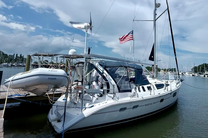 The Image of Sailboat Hunter 410, 1998 model, docked with American flag, clear sky background. - 0