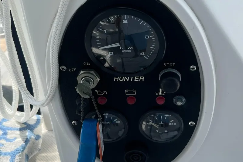 Slide: The Image of Control panel of a 1998 Hunter 410 boat with gauges and ignition key. - 12