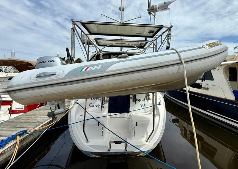 Slide: The Image of 1998 Hunter 410 yacht with inflatable boat on davits, docked at marina. - 17
