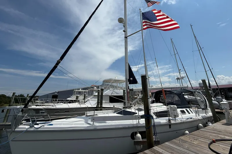 Slide: The Image of Sailboat docked at marina, Hunter 410 model, 1998, with American flags waving. - 2